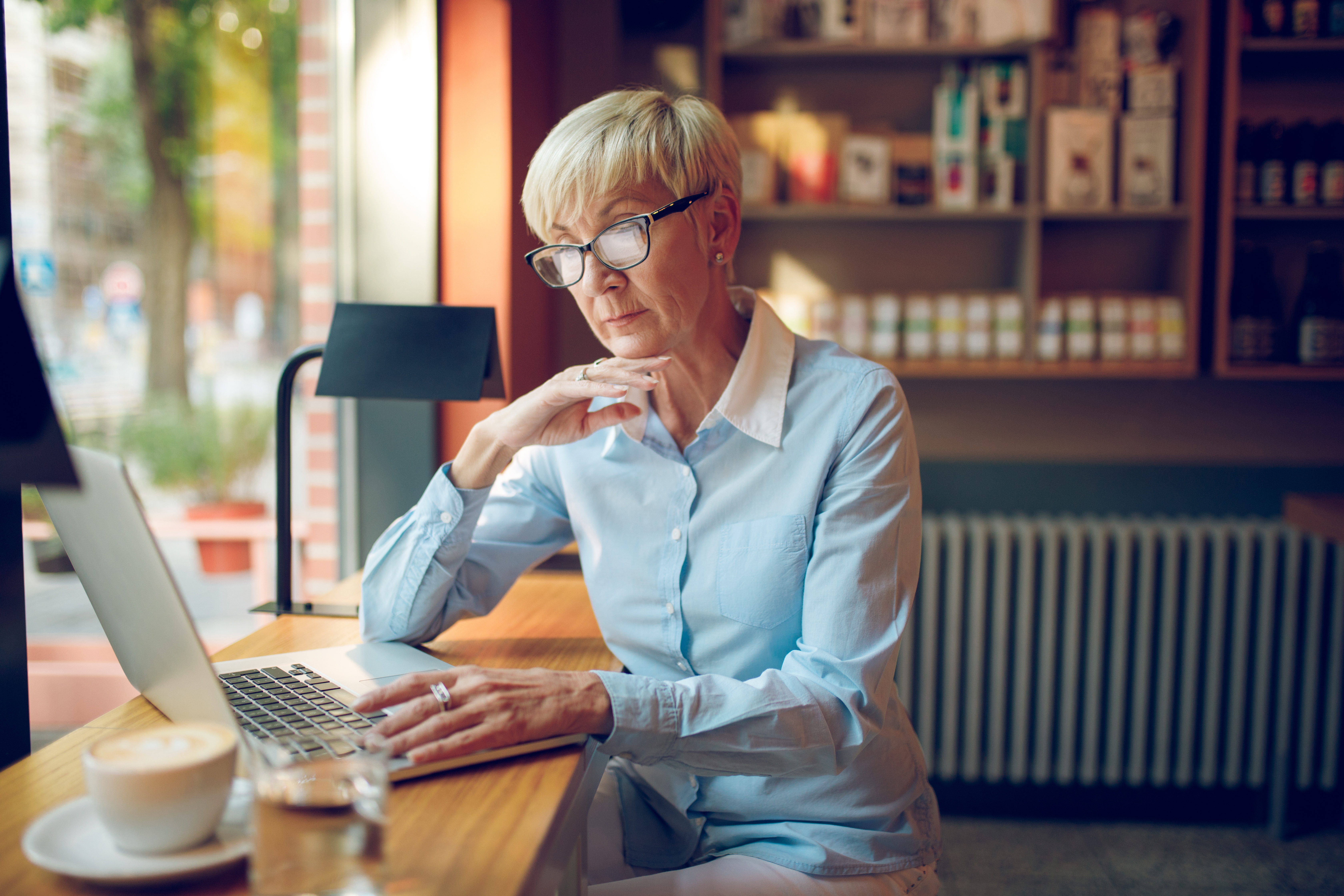 a woman sitting sitting on her desk reading computer