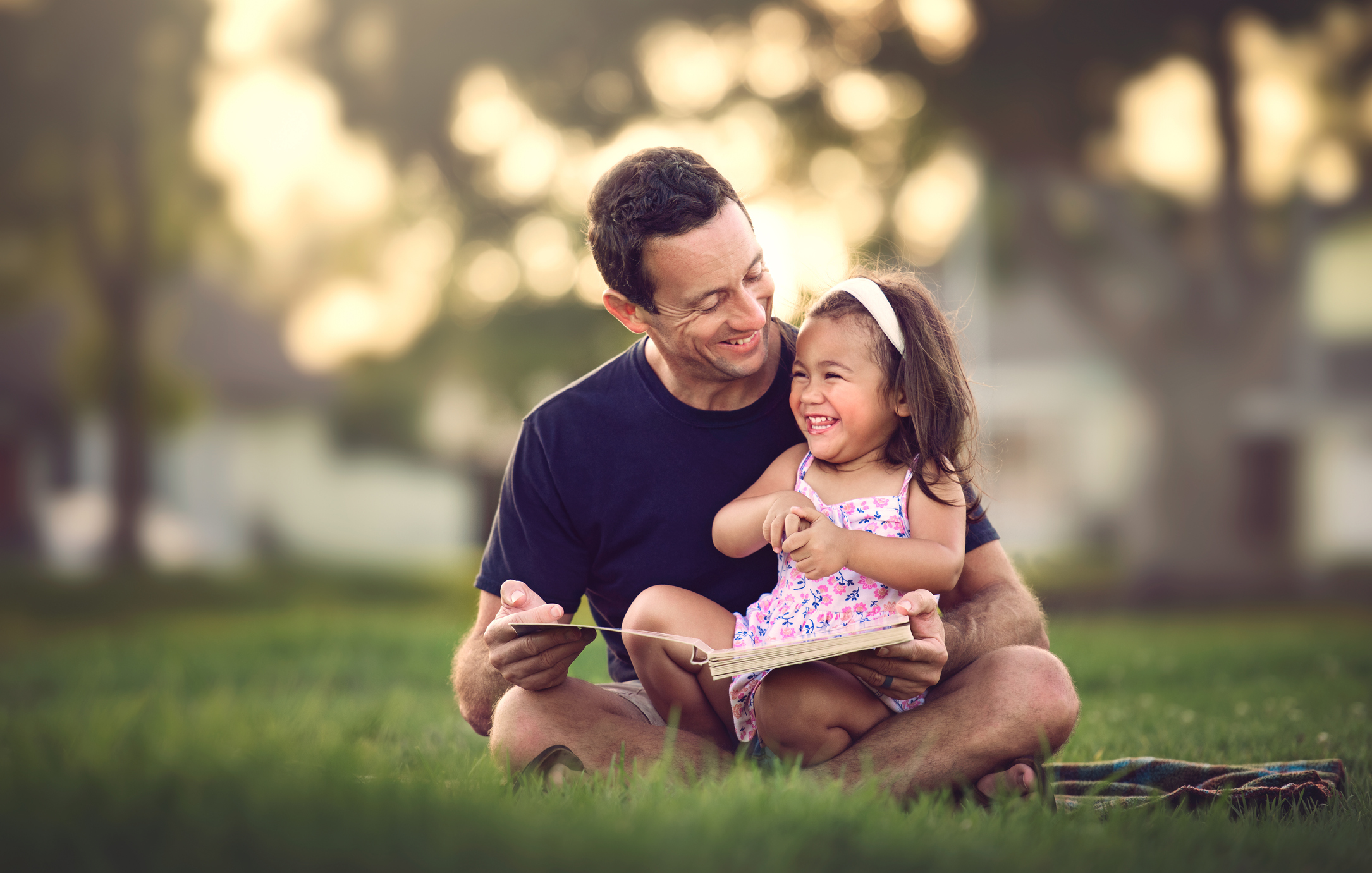 An image representing a father and a daughter laughing and playing.